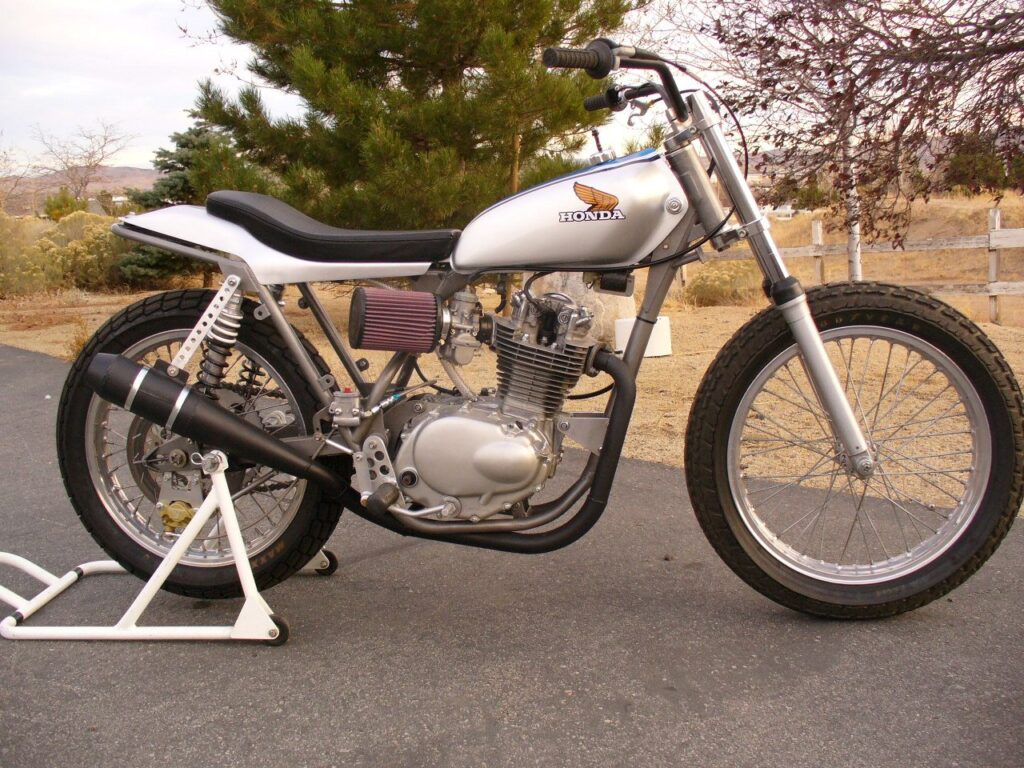 Silver street tracker with a white tank on a work stand